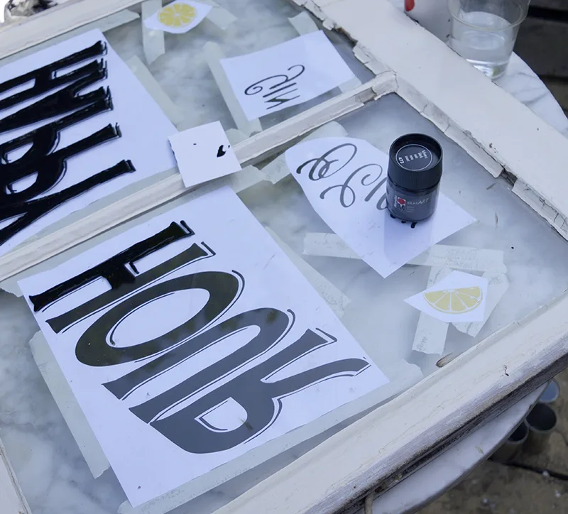 painting a sign on a glass window