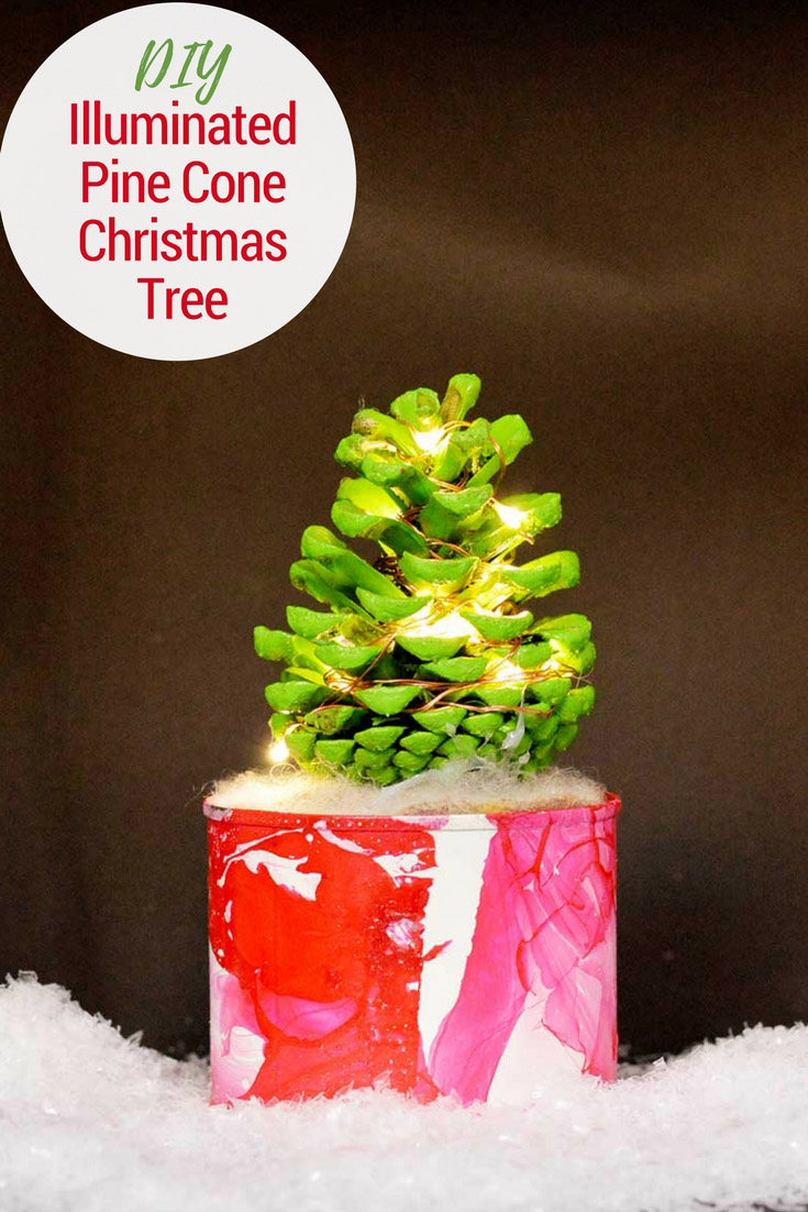 How to make a cute illuminated pine cone Christmas tree in a marble pot. This colorful Christmas tree complete with copper lights will brighten up any desk. #christmascrafts #christmas #pinecone #christmaslights