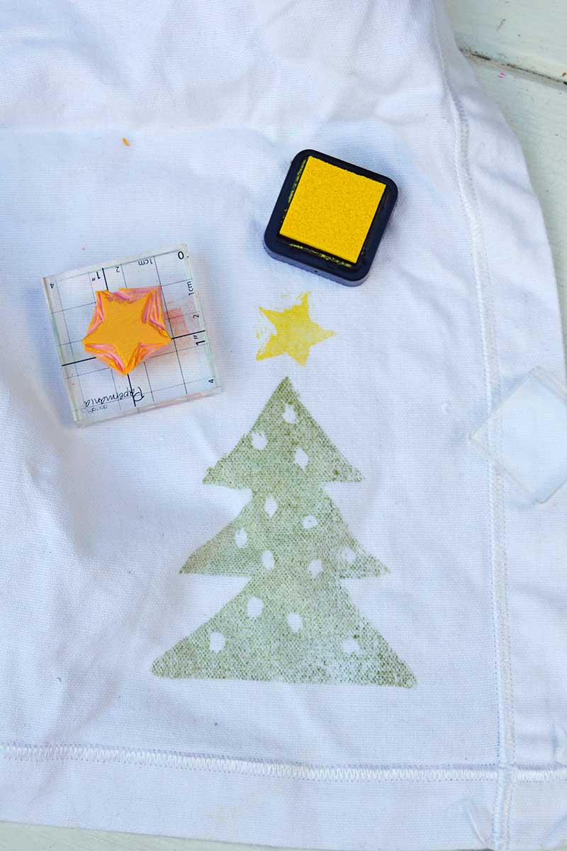 stamping Christmas tree onto white fabric