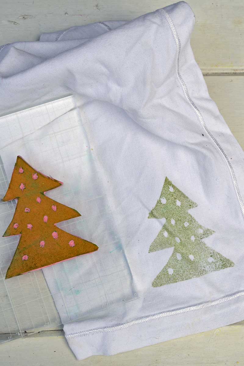 stamping Christmas tree onto white fabric