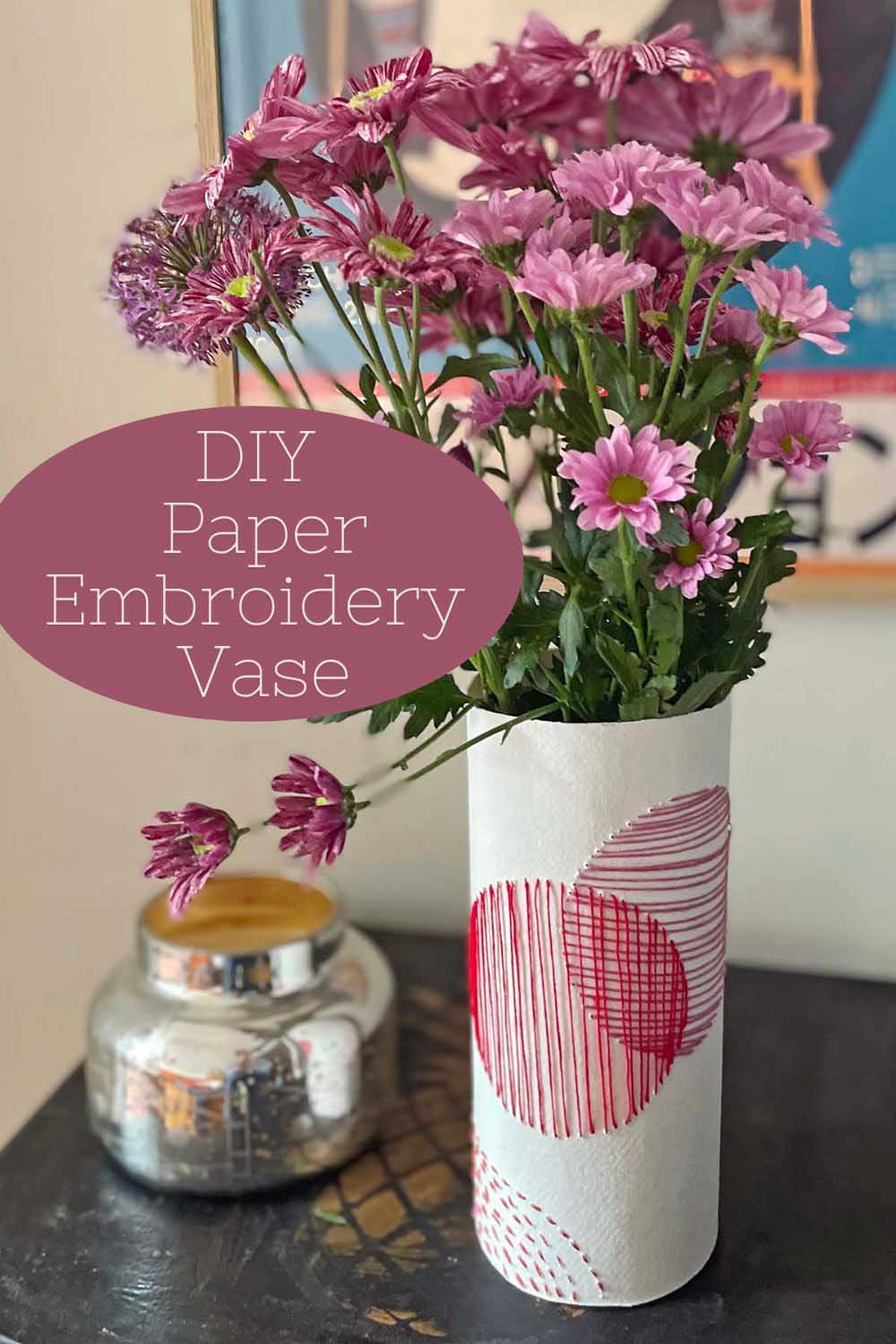 paper embroidery vase sleeve with flowers on table with candle