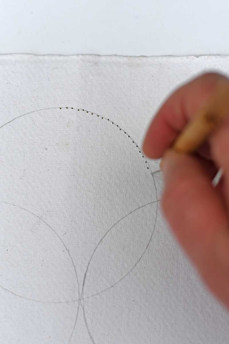 punching holes in handmade paper for preparing for hand embroidery