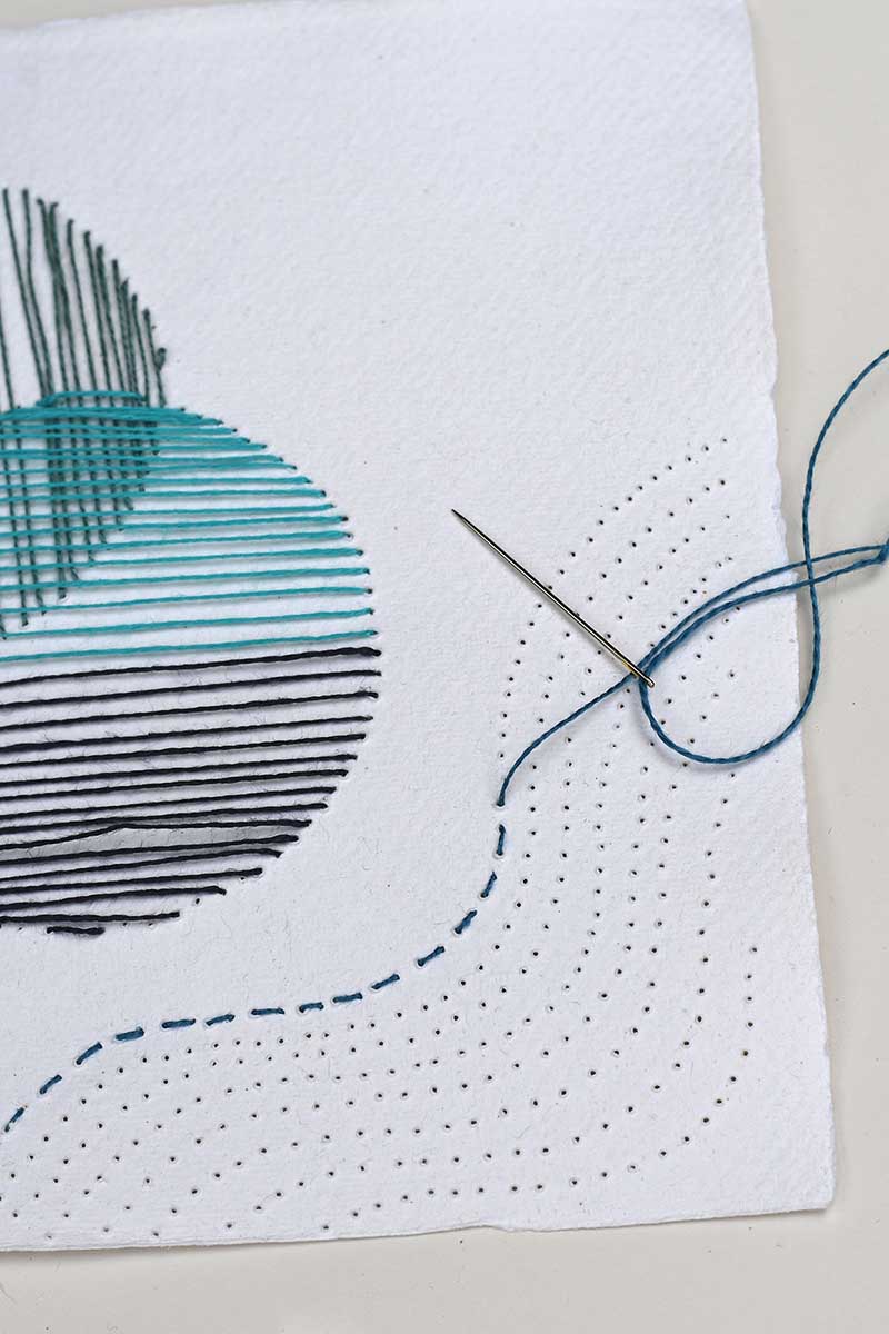 Stitching the wave pattern on the handmade paper by hand