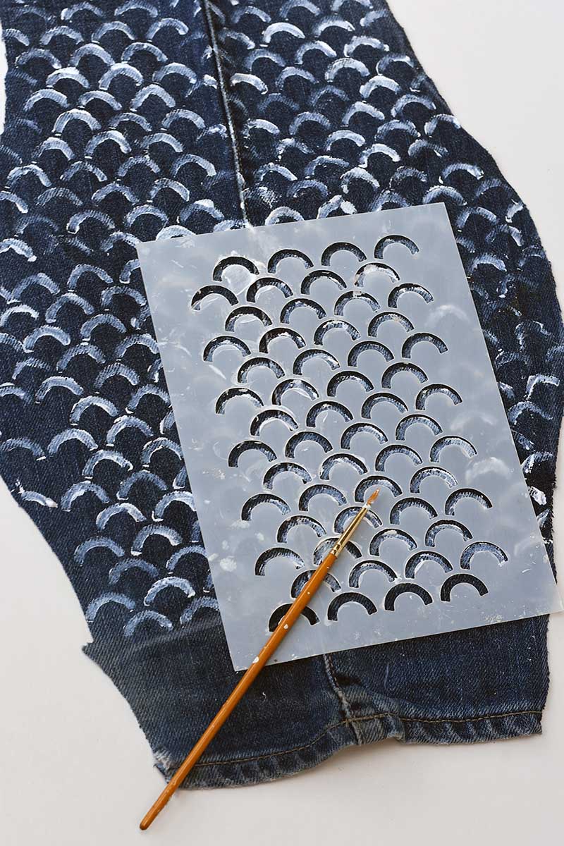 Painting on the fish scales onto the denim