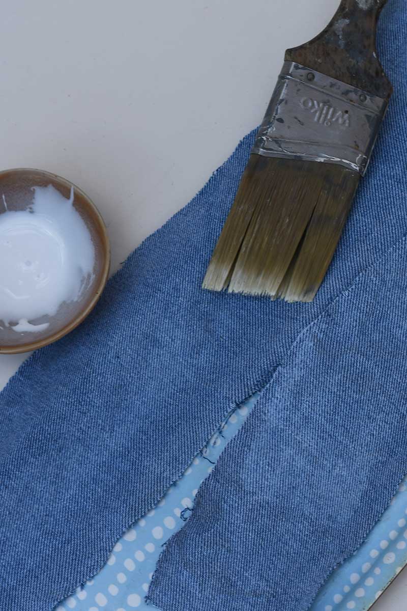 applying fabric stiffener with a brush to denim fabric