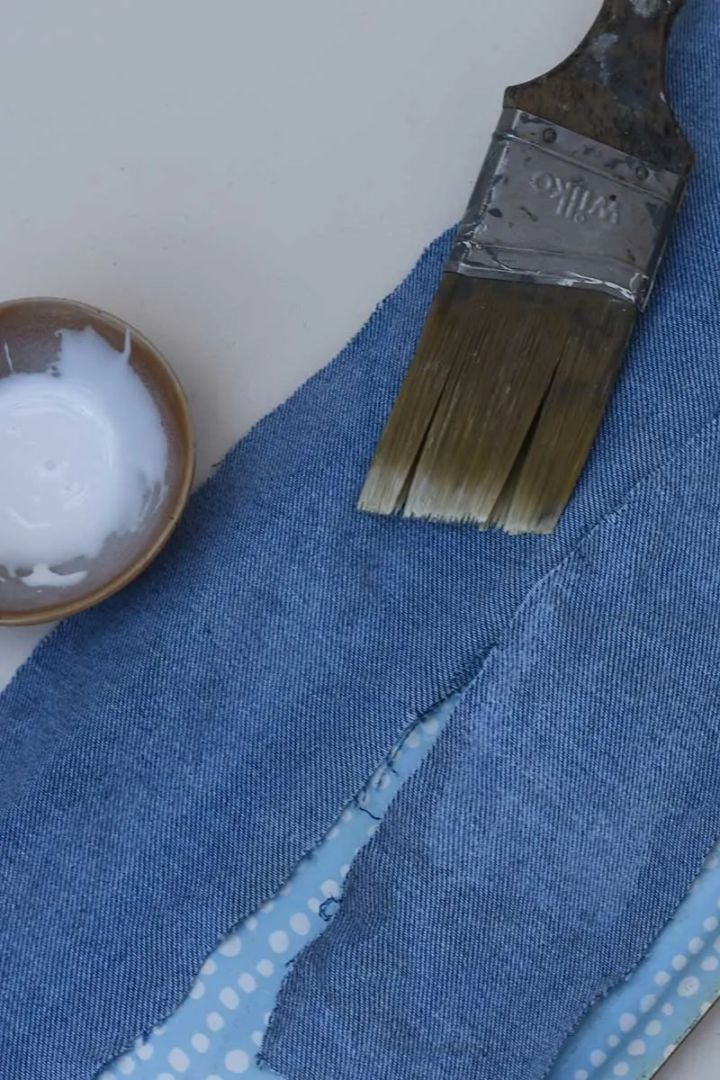 applying fabric stiffener with a brush to denim fabric