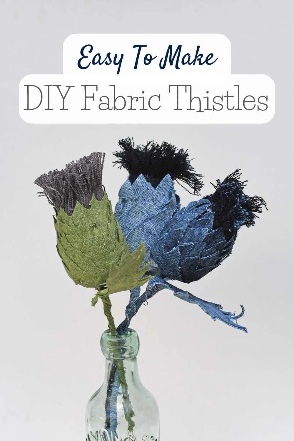 three DIy fabric thistles in a clear bottle vase with text overlay.