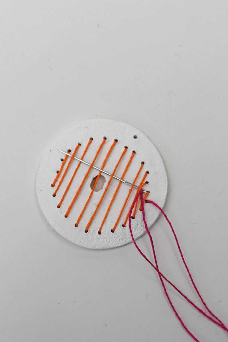 Creating vertical stripes in orange thread on a clay disc