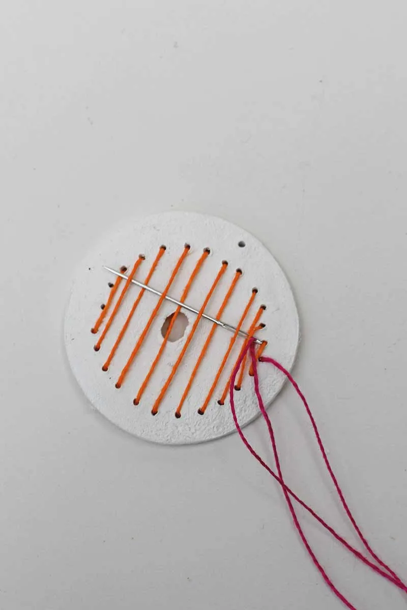 Creating vertical stripes in orange thread on a clay disc