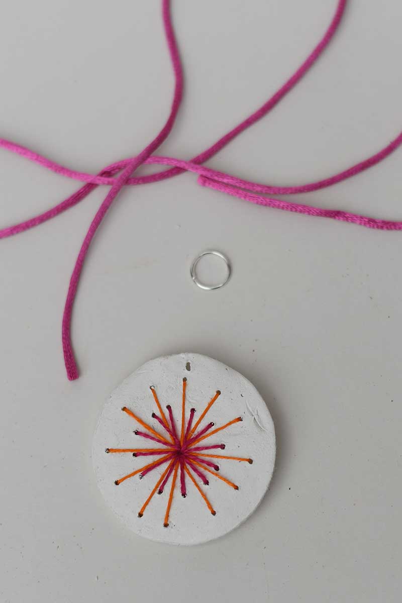 embroidered pendant with pink orange sun burst o-ring and pink jewellery cord