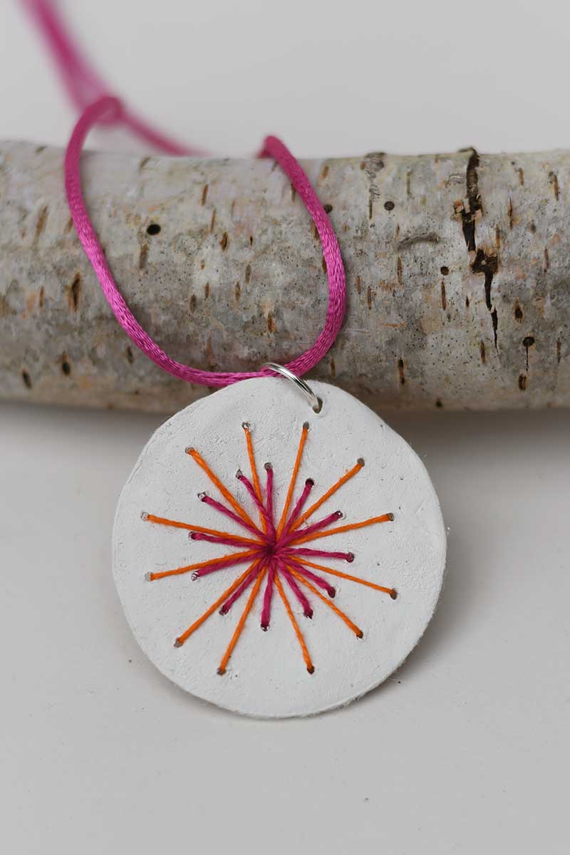 embroidered clay pendant necklace sunburst design