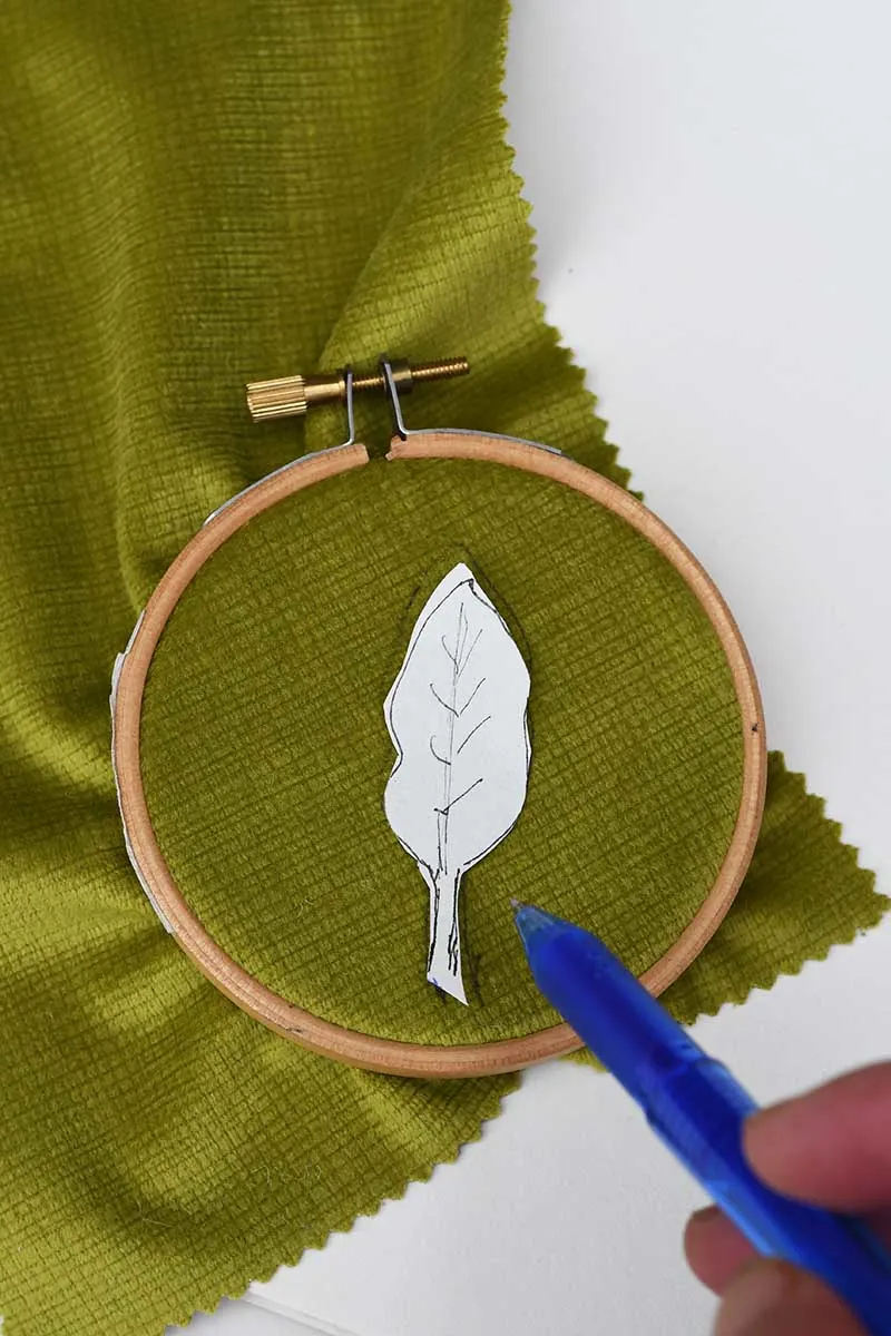 Drawing around the leaf shape pattern onto green fabric