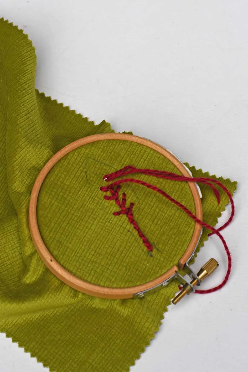 embroidering a beetroot leaf for a DIY beet brooch.