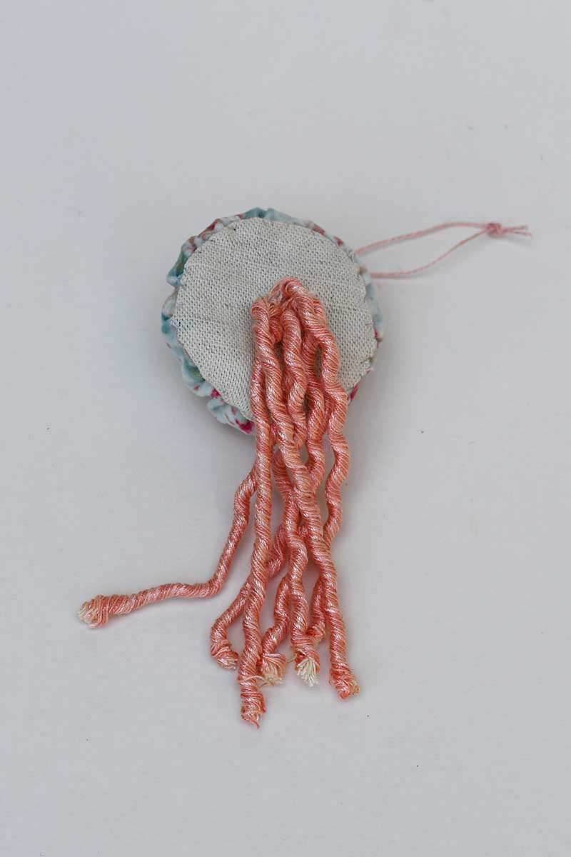 sewing twine tentacles to base of the DIY fabric Jellyfish 