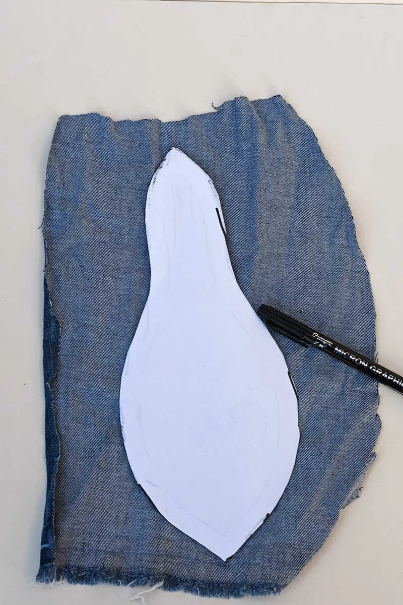 Drawing around the paper pear template on a piece of denim fabric