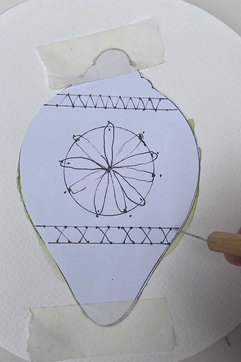 diy paper embroidery pattern taped over watercolour bauble with punching needle