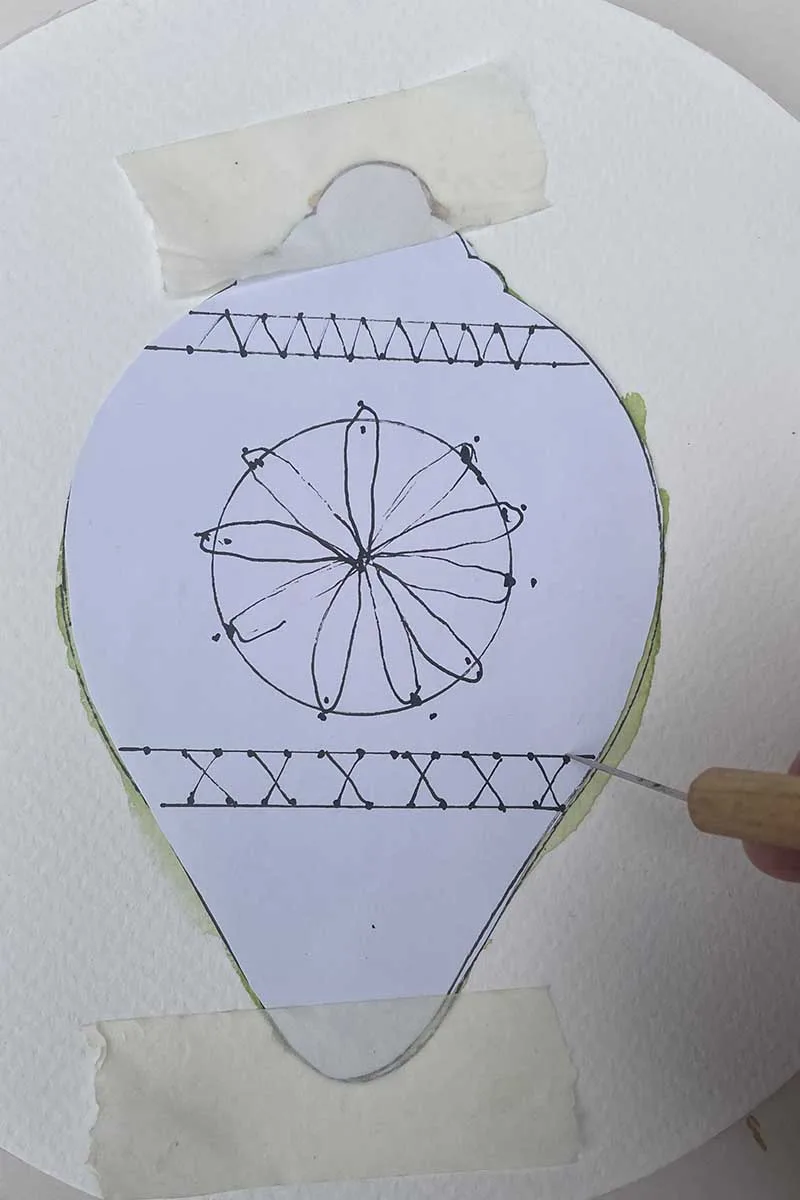 diy paper embroidery pattern taped over watercolour bauble with punching needle