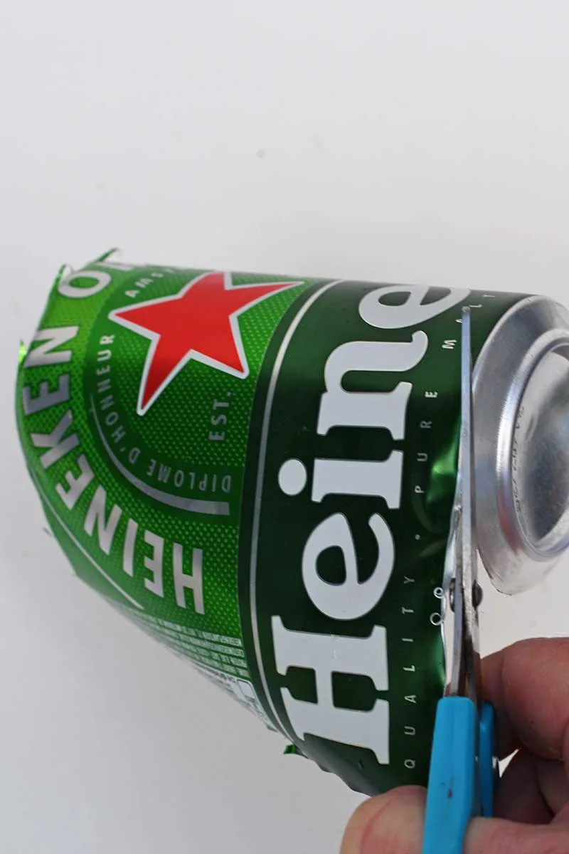 cutting a Heineken Can with scissors