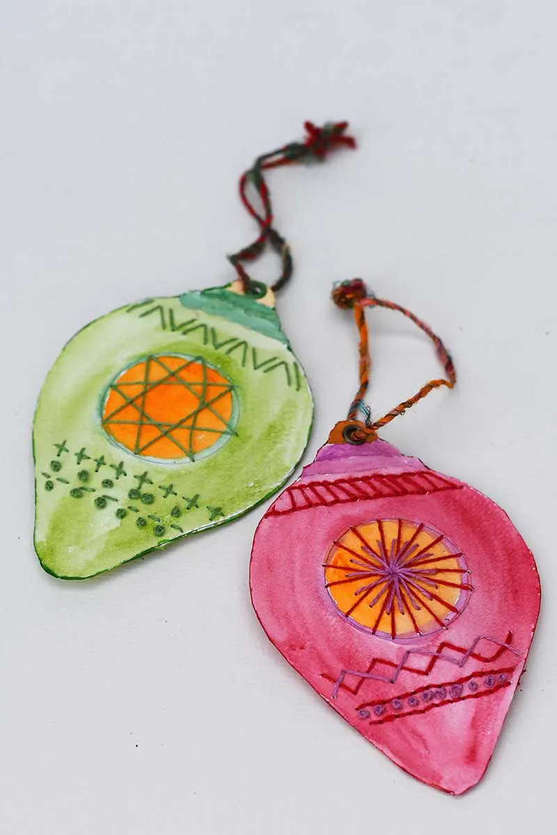 Green and red embroidered paper Christmas baubles with watercolour paint