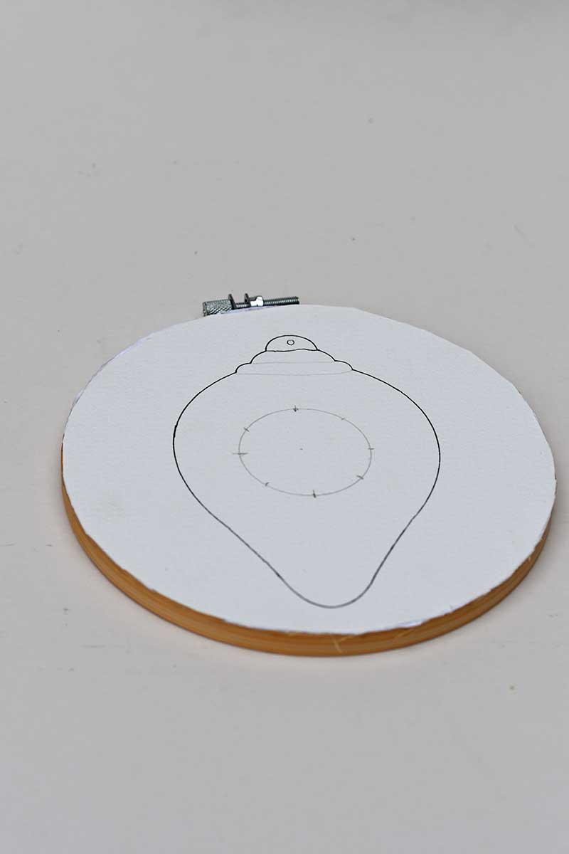 watercolour paper with bauble design stuck to embroidery hoop