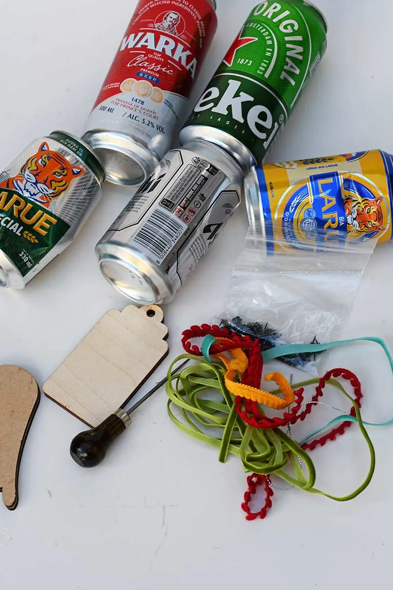 craft beer cans, wooden shapes, awl, and ribbon