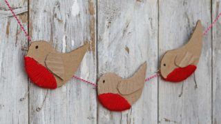 three cardboard robin ornaments in a garland