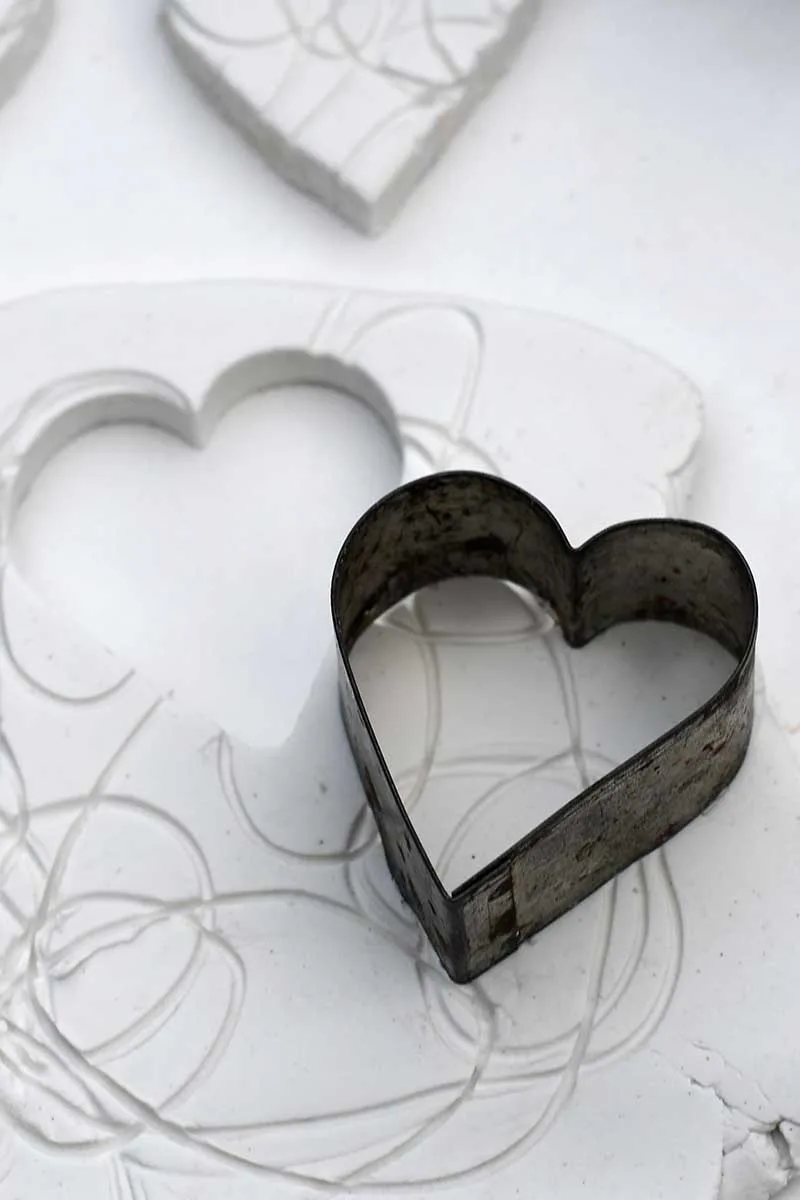 cutting out air dry clay Valentines hearts for a decoration