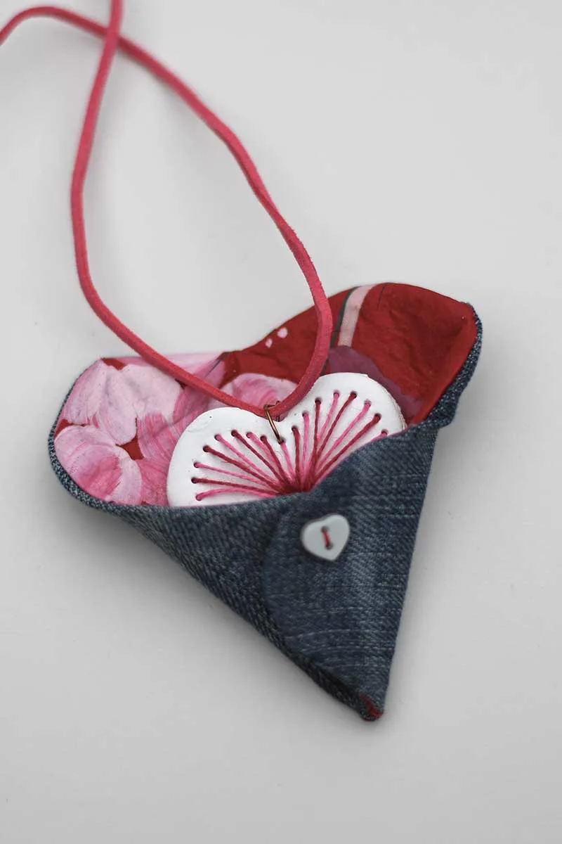 embroidered clay heart in a scrap fabric and denim heart pocket