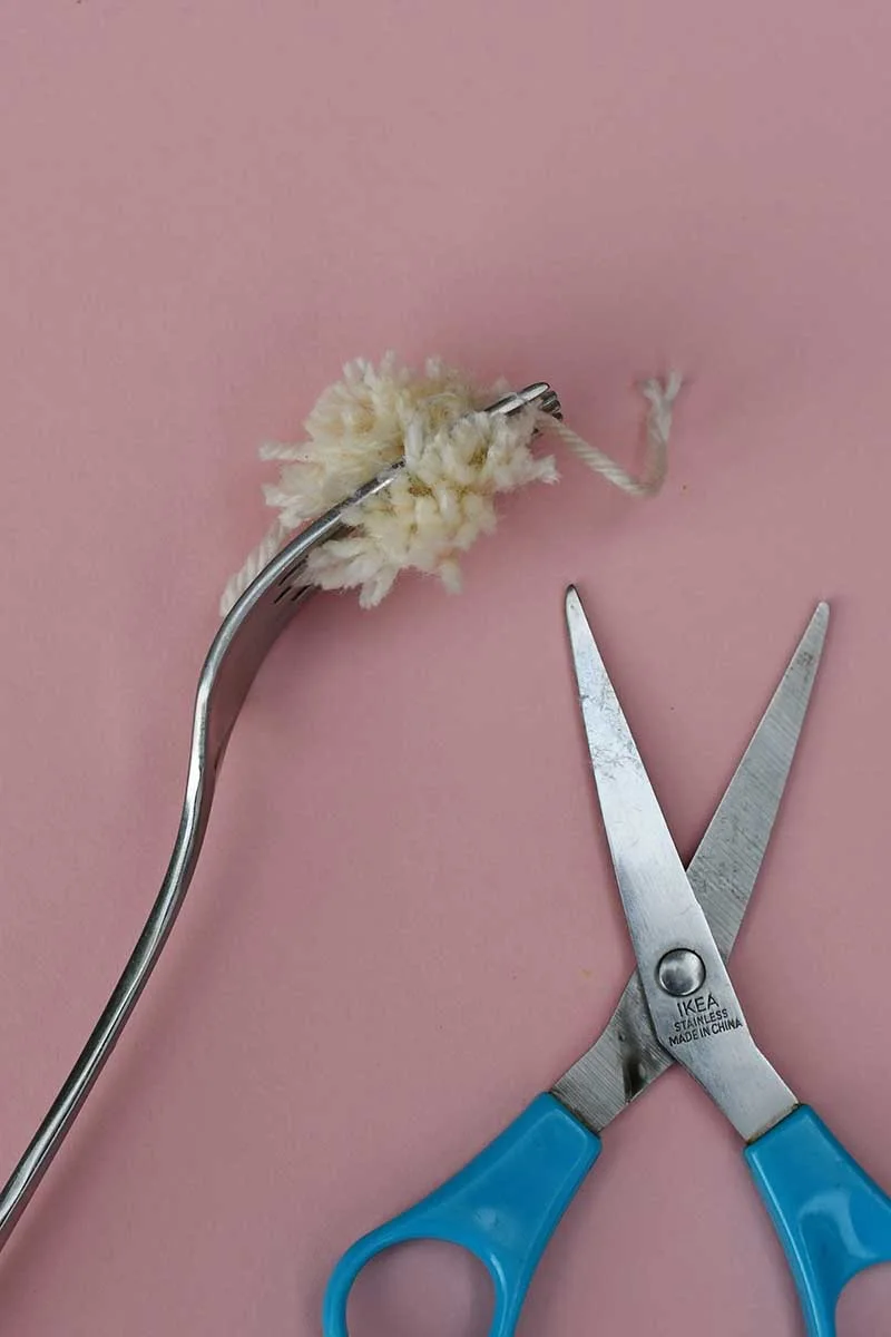 making a pom pom on a fork